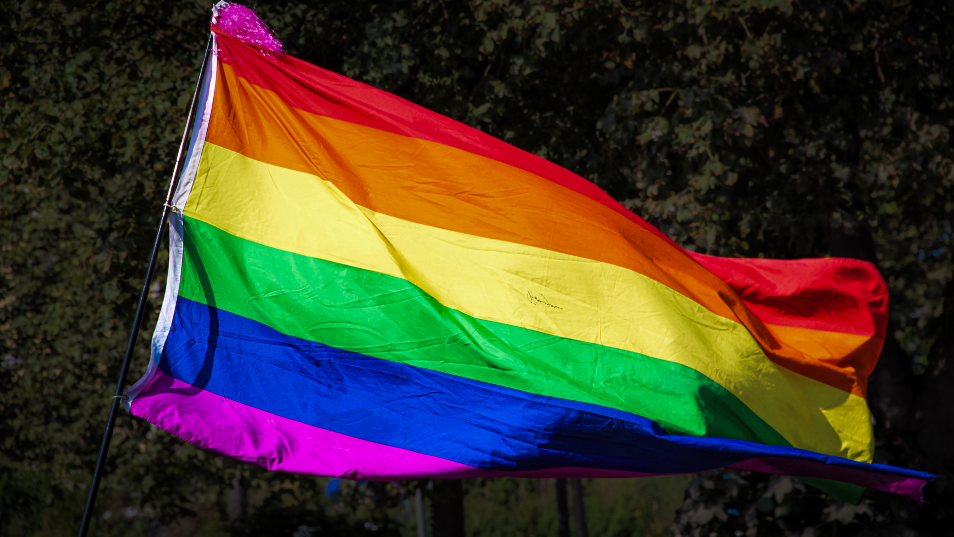 Eine Regenbogenflagge weht im Wind.